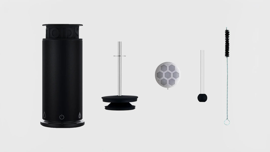 The NOIDS Herb Lab with its lid, filter, glass pipette and cleaning brush laid out on light grey