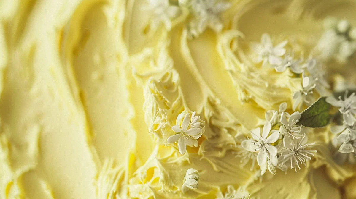 Close-up of soft whipped butter with small white flowers and herbs